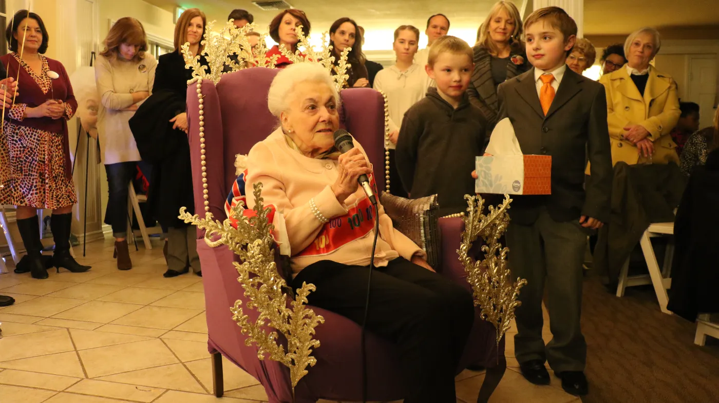 Grandma Eileen speaking from a purple throne at her 100th birthday