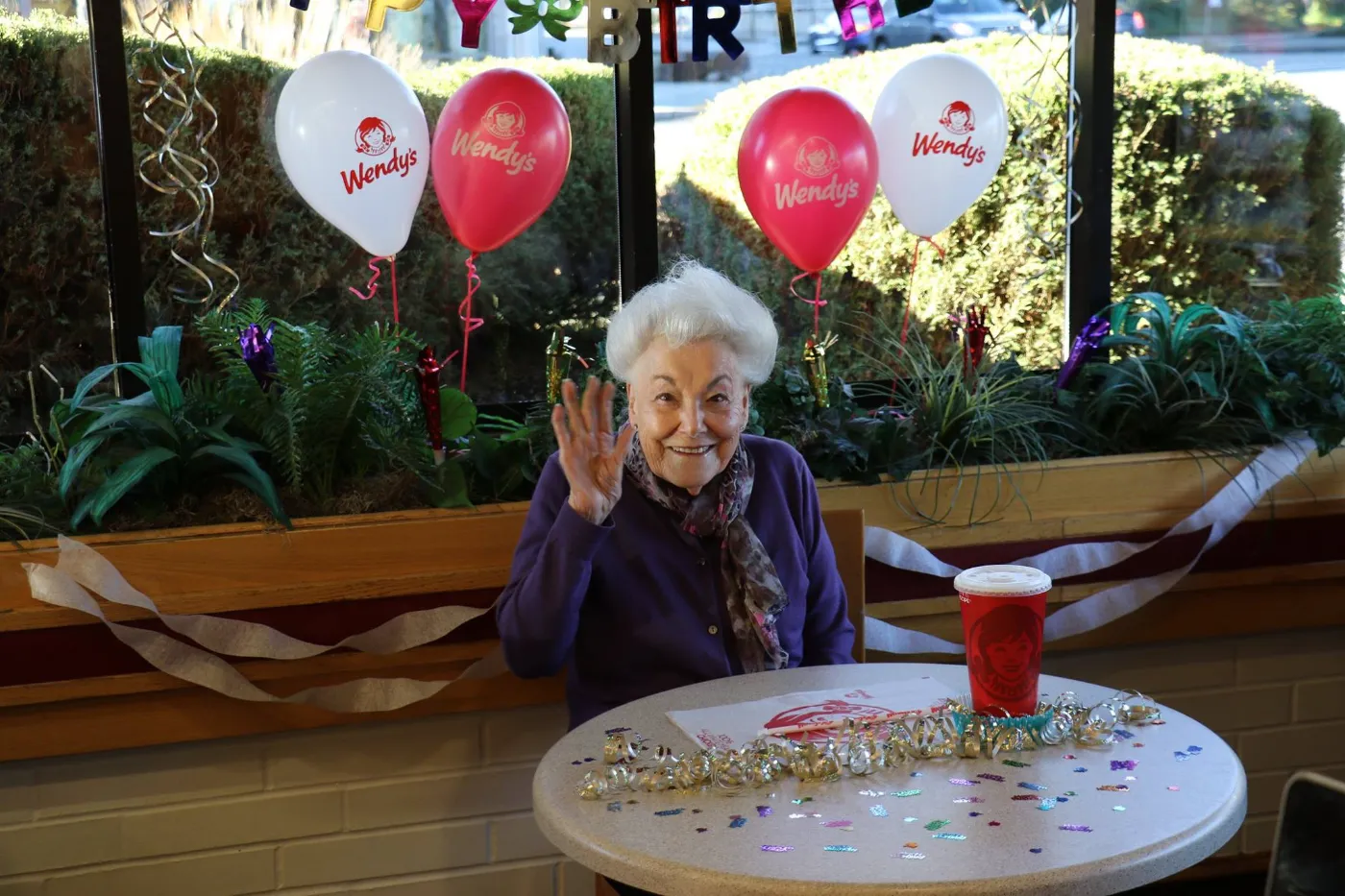 Grandma Eileen waving at her birthday party at Wendy's
