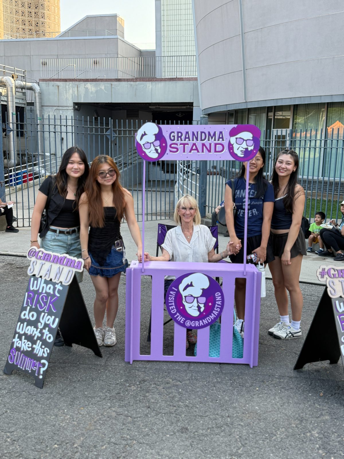 A grandma with four young women posing at the stand