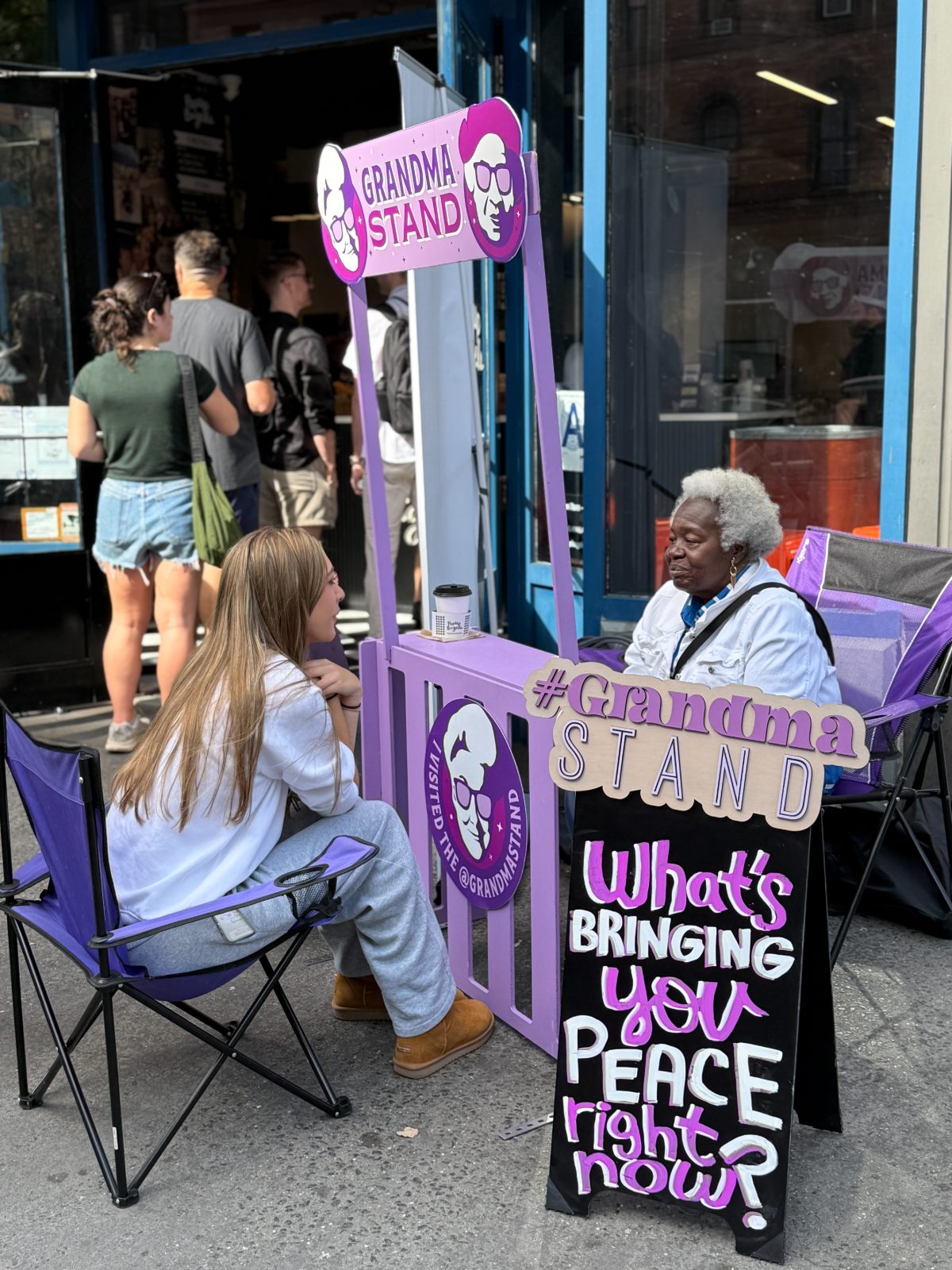 A grandma talks with a young woman outside a bagel shop